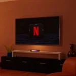 Sala de estar con televisor mostrando el logo de Netflix y una barra de sonido encendida sobre un mueble blanco, junto a sillones rojos y decoración hogareña.